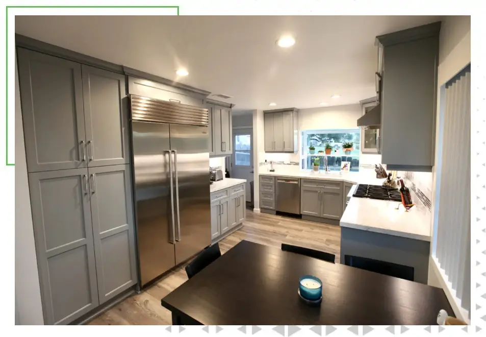 A kitchen with stainless steel appliances and wooden floors.